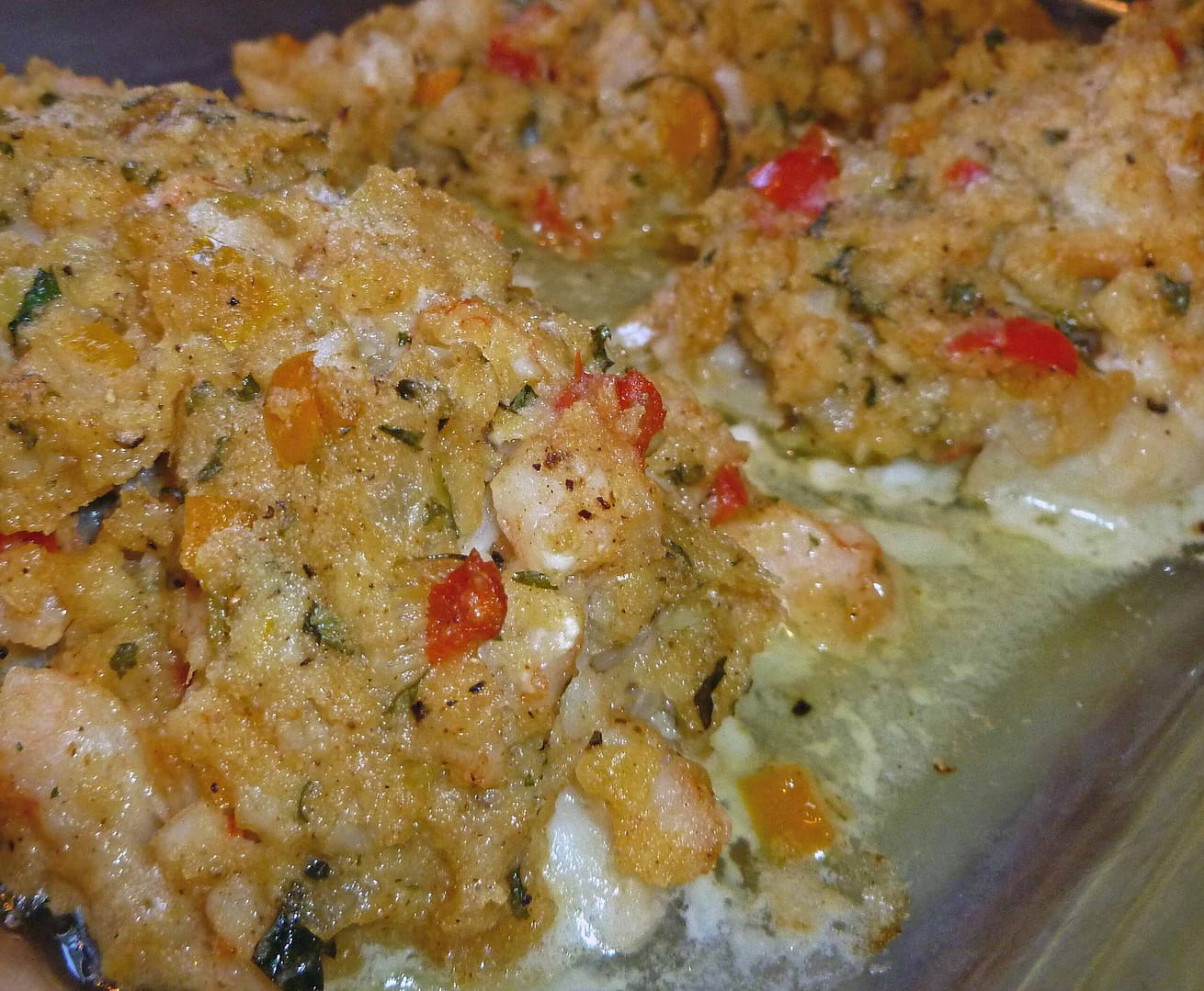 Oven-baked cod fillets topped with golden seafood stuffing made with shrimp, peppers, herbs, and buttery cracker crumbs, fresh from the oven