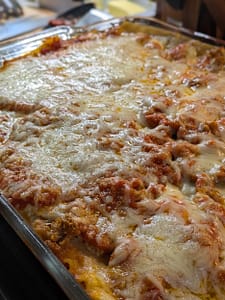 Homemade meatball and sausage lasagna layered with ricotta, marinara sauce, and melted mozzarella, served hot and cheesy from a glass baking dish