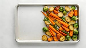 Sheet Pan Roasted Vegetables Carrots Potatoes Brussels Sprouts Rosemary On White Background Overhead View