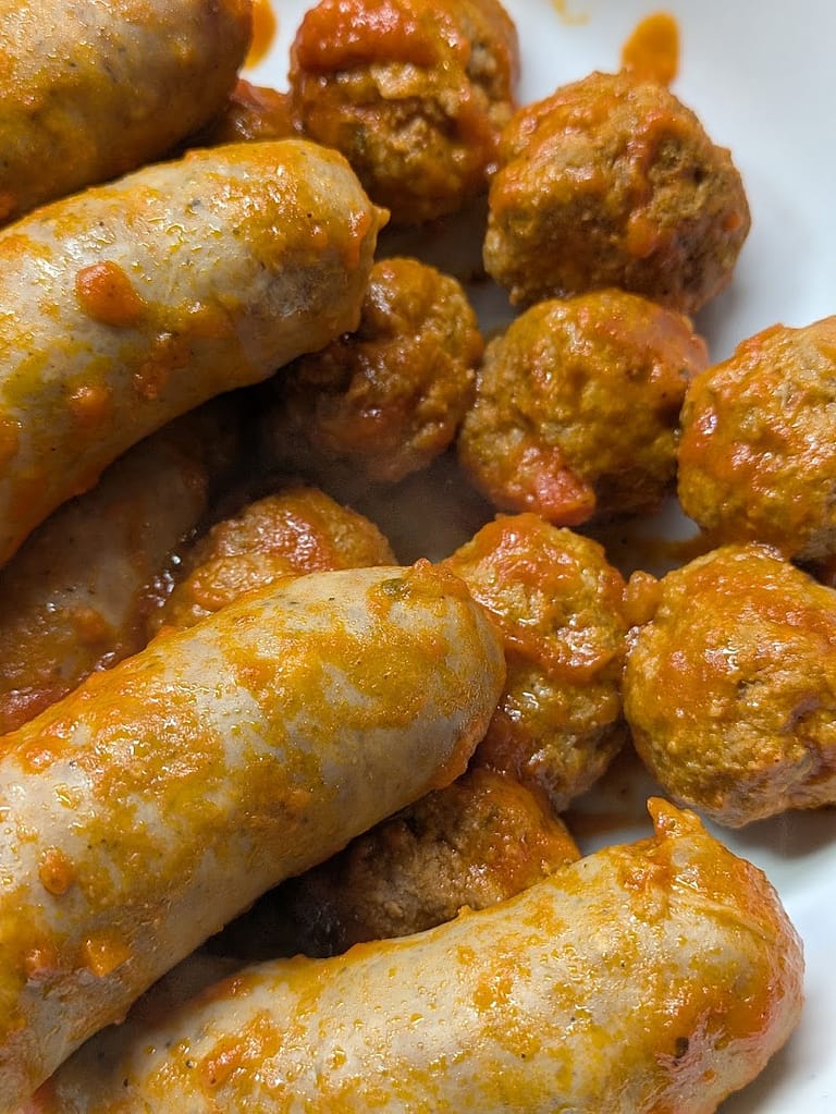 Italian sausage links and homemade meatballs just out of the rich marinara sauce for lasagna, seasoned with garlic, herbs, and crushed tomatoes